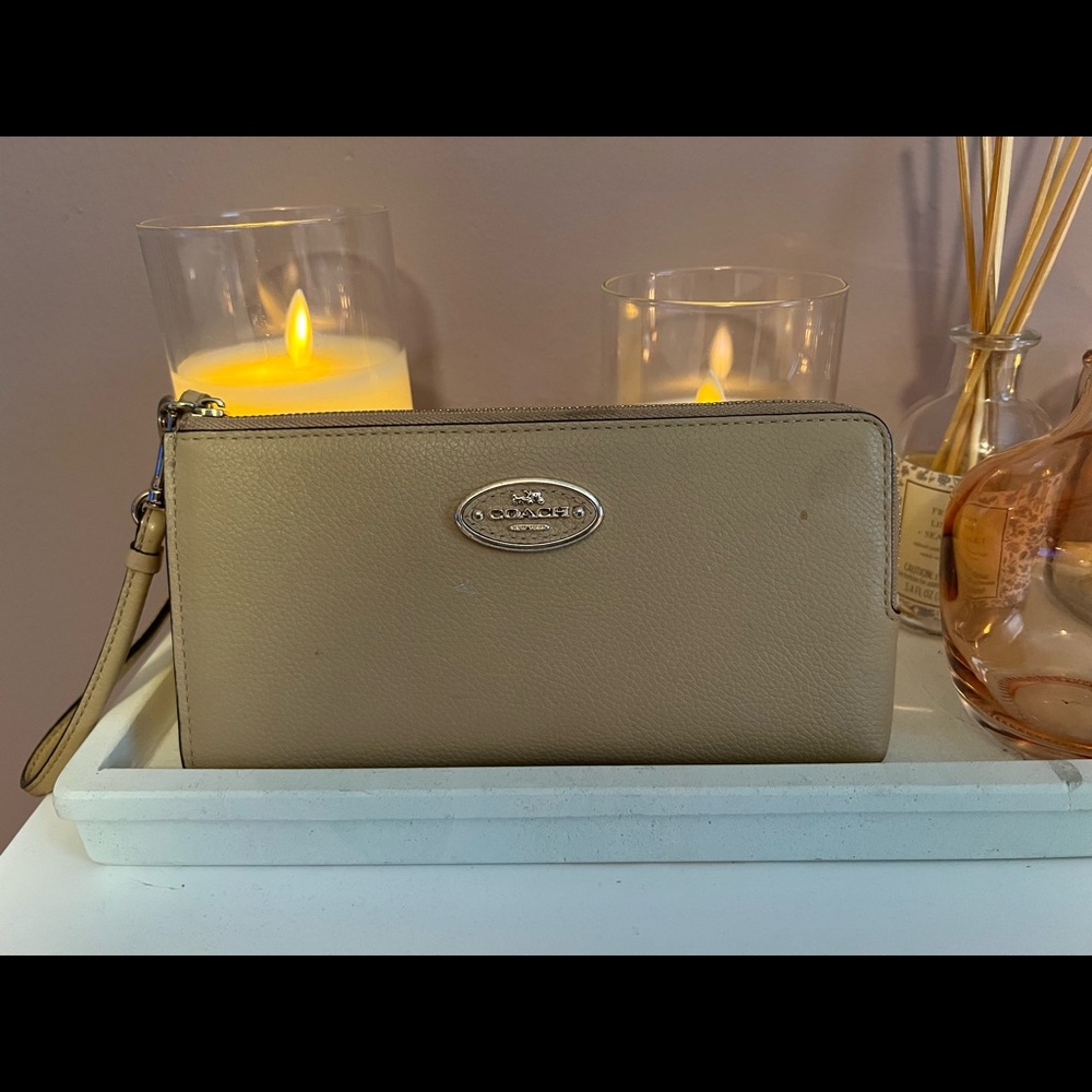Beige coach wristlet. Wristlet is used. There are a few marks.